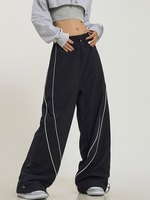Maßgeschneiderte gestreifte, weit geschnittene, sportliche Windbreaker-Nylon-Trainingshose mit Paspelierung, Baggy Parachute Pants, gestreifte Sweatpants für Herren