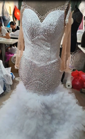Robe de mariée sirène de luxe blanche perlée 2026 avec encolure illusion transparente, manches longues et traîne volumineuse à volants