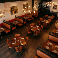 Table en bois avec pieds en acier inoxydable, canapé en cuir rouge, ensemble de chaises marron, style moderne rétro pour steakhouse, café, restaurant, hôtel