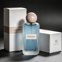 Flacon de parfum vide rectangulaire long givré bleu brumeux à paillettes, avec bouchon boule rose nude, plaque nominative blanche, logo personnalisé et coffret cadeau