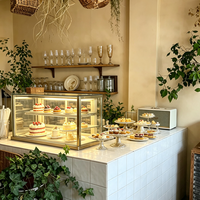 Vitrine en verre sur mesure de luxe pour café, adaptée au design intérieur de café.