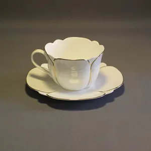 Tazas y platillos de té real con forma de flor de lirio, juego de té de porcelana con adorno dorado para taza de té blanco