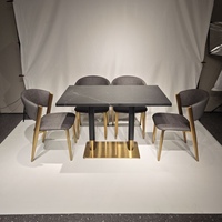 Table à manger en pierre frittée noire avec base en acier inoxydable et accents dorés