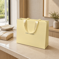 Sac cadeau en papier jaune clair, sac de transport en papier d'art, sac de shopping personnalisé avec logo pour l'emballage de vêtements et de produits de beauté