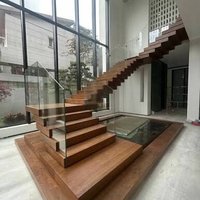 Escalier flottant empilé sur mesure avec garde-corps en verre, structure en bois durable et marches en bois massif pour les intérieurs de villas haut de gamme