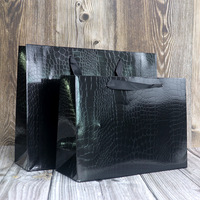 Sac en papier noir personnalisable avec motifs lézards et crocodiles, film brillant, sac cadeau haut de gamme et tendance pour magasin de vêtements