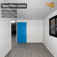 Maison conteneur moderne extensible Huaying de 40 pieds avec cadre en bois noir et intérieur jaune désert, dotée de caractéristiques coupe-vent et imperméables