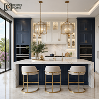 Meubles de cuisine modernes bleu marine style américain, îlot double cascade en marbre Statuario, lanterne en laiton, menuiserie sur mesure pour penthouse