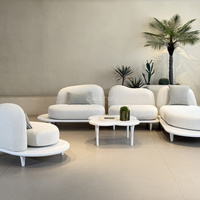 Ensemble de canapés d'extérieur modernes avec sièges arrondis et tables basses de forme originale