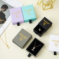 Boîte de rangement pour bijoux A1, collection sélectionnée, avec intérieur noir, logo doré et poignée frontale pour une présentation en boutique