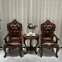 Fauteuil à dossier sculpté en bois massif de style européen avec accoudoirs, recouvert de cuir pleine fleur