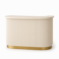 Bureau d'accueil moderne de luxe blanc crème cannelé avec base dorée et façade incurvée pour salon, boutique, bureau, hall d'entrée