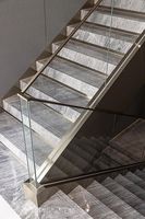 Balustrade en verre avec main courante en acier et poteaux verticaux pour installations d'escaliers résidentiels