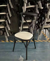 Chaises noires en fer à dossier croisé pour événements extérieurs, avec coussin, empilables et au design moderne, pour hôtels, fêtes et événements