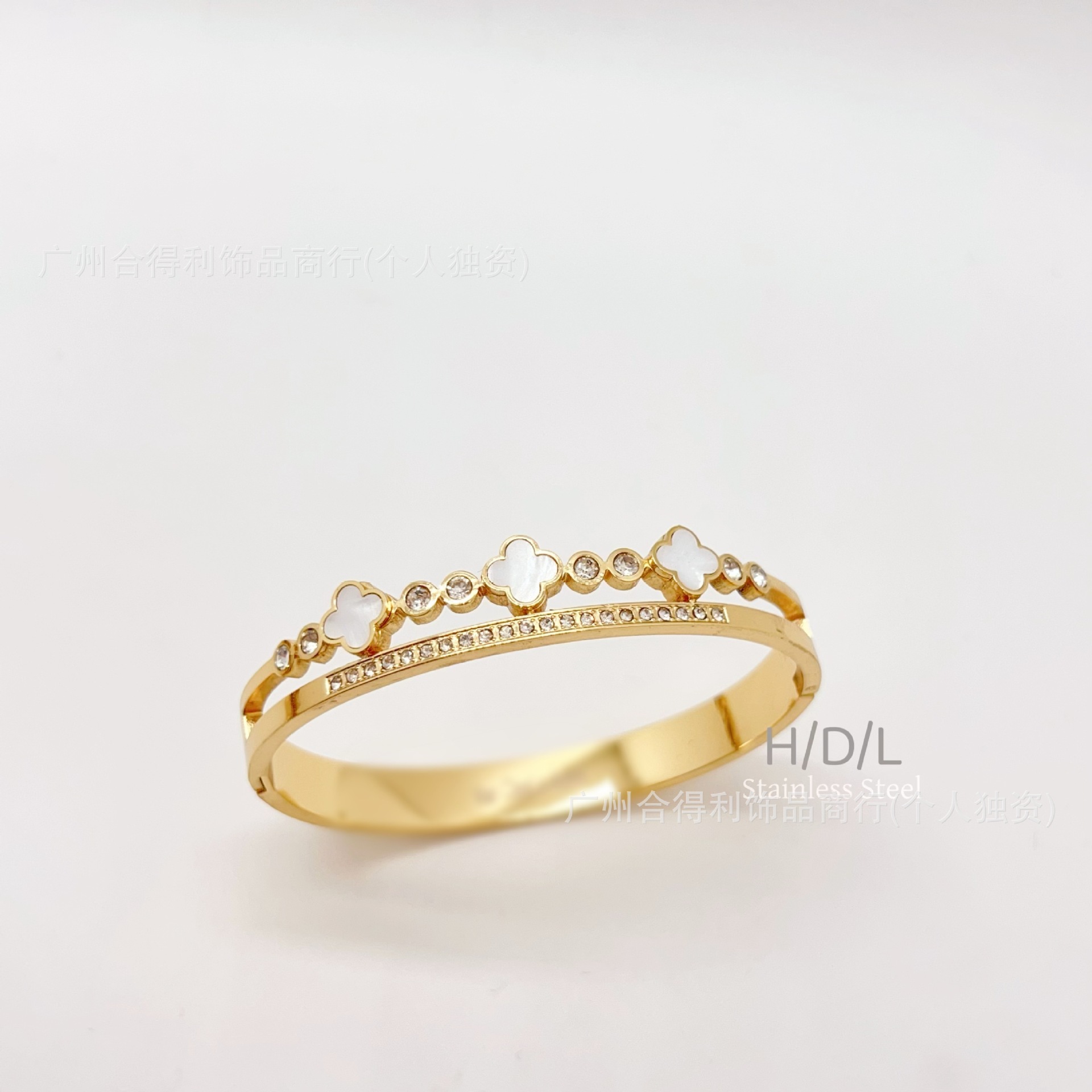 Bracelet en or avec 3 trèfles à quatre feuilles en nacre blanche.