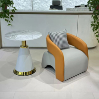 Fauteuil lounge et table basse en cuir, style minimaliste moderne, robustes et durables, adaptés à l'utilisation dans les hôtels et les salons.