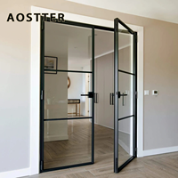 Porte battante AOSTTER noire en aluminium mince avec vitrage transparent pleine hauteur et charnière dissimulée pour un intérieur minimaliste