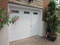 Porte de garage extérieure moderne en acier avec fonction antivol, surface finie, porte piétonne et insert de fenêtre