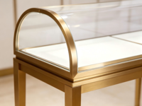 Comptoir de présentation de bijoux en verre incurvé de luxe, pieds en métal doré brossé, logo personnalisé, éclairage LED, vitrine de vente au détail pour centre commercial