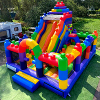 Château gonflable commercial en PVC avec toboggan et blocs de construction Lego, personnalisable en couleur et logo