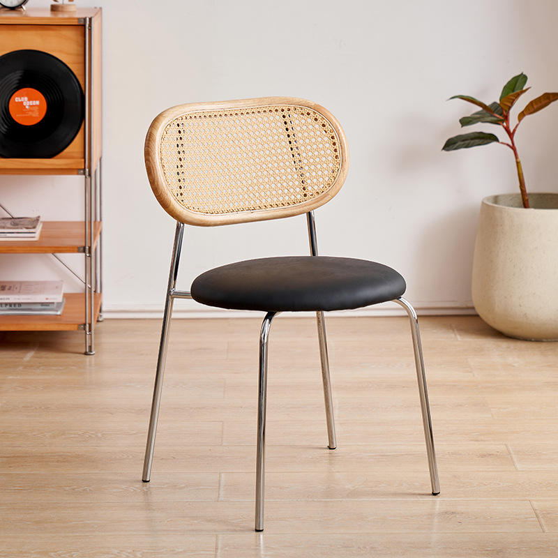 Respaldo de madera natural, cojín de asiento negro mate, patas plateadas.