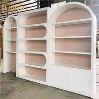 Meubles de présentation modernes blancs pour salons de beauté, vitrines de magasin de soins de la peau avec éclairage LED, rangements muraux arqués, boutique de beauté haut de gamme