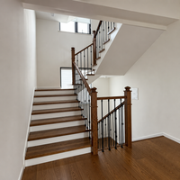 Escalier en bois massif courbé avec balustrade en fer forgé à motif festonné, escalier intérieur en bois pour villa résidentielle