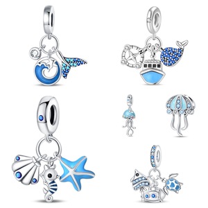 Un conjunto de pulseras con colgantes de animales marinos en latón blanco plateado, adornadas con esmalte azul y diamantes de imitación. - Product Image 1