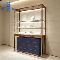 Kiosque à bijoux en forme de L personnalisé pour centre commercial, avec pieds en métal couleur or champagne, vitrine en verre et comptoir de caisse pour bijouterie