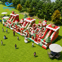 Château gonflable commercial sur le thème de Noël pour événements festifs, avec toboggan et jeux de saut en plein air pour enfants