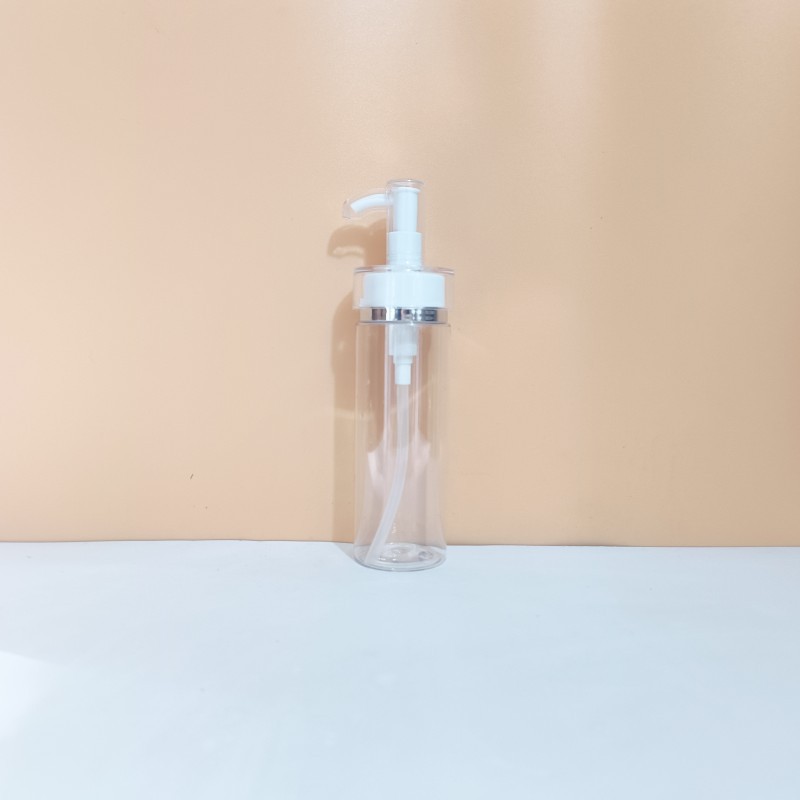 Botella transparente con bomba de borde plateado.