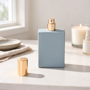 Flacon de parfum en verre bleu clair de 50 ml, conteneur rectangulaire plat, bouchon cylindrique doré brillant, emballage en vrac OEM ODM - Product Image 1