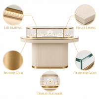 Vitrine à bijoux ovale moderne en verre avec base rainurée et surface incurvée éclairée par LED
