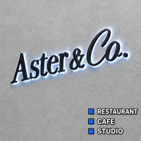 Emblème monogramme doré poli effet miroir avec lettres lumineuses à halo en serif, enseigne logo personnalisée pour façade murale en pierre, enseigne en lettres encastrées
