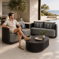 Ensemble de canapés d'extérieur en aluminium gris foncé de luxe moderne, table basse ovale cannelée, fauteuils cylindriques confortables pour cour et patio