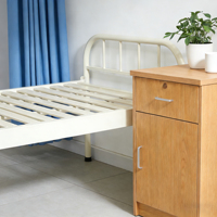 Lit médical manuel fixe pour soins à domicile et hôpital, avec cadre en tubes d'acier, capacité 240 kg, crochets IV réglables pour drainage en salle.