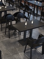 Ensemble de meubles de restaurant modernes entièrement noirs, table à manger minimaliste en noir mat et fauteuils sculpturaux