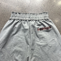 Shorts amples en molleton à jambes larges avec logo personnalisé, ourlet effiloché, taille élastique à volants, empiècement à carreaux et poche arrière, style streetwear