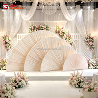 Décor de mariage élégant : Arche de toile de fond semi-circulaire avec supports en forme d'éventail et draperies
