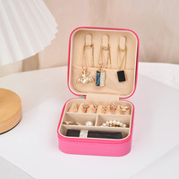 Boîte à bijoux carrée en similicuir vegan format pochette, fermeture éclair intégrale, avec rouleaux à bagues non amovibles, crochets pour colliers et compartiment à rouge à lèvres, coloris Noir, Rose, Rose Vif