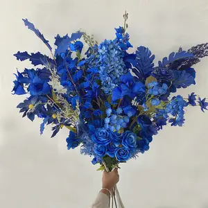 الزهور المزيفة المزينة بزهور حفلات الزفاف المزينة باللون الأزرق الملكي والحريرية تُعلّق على سقف مقوس يقود إلى طريق الزفاف