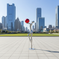 Sculpture humaine abstraite moderne en acier inoxydable poli miroir OEM/ODM, boule rouge, grande décoration artistique métallique d'extérieur personnalisée