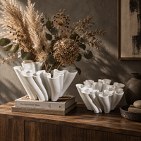 Vase en céramique blanche avec un design sculptural fluide pour fleurs et décoration intérieure