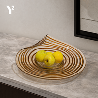 Luxueuze gedraaide spiraalvormige glazen schaal met amberkleurige tint voor fruitpresentatie in de woonkamer, op de salontafel of dressoir.