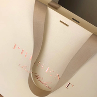 Sac en papier personnalisé pour marque de vêtements, sac en papier cartonné blanc 250g, logo imprimé or rose, design avec ruban suspendu