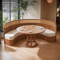 Banquette à dossier haut avec dossier en rotin et assise crème, table ronde en bois avec chaises et tables à piétement en bois pour la restauration et l'hôtellerie