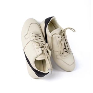 Chaussures de sport en cuir de luxe de créateur avec des rayures triangulaires simples. Sandales basses décontractées. Convient aux hommes et aux femmes - Product Image 1