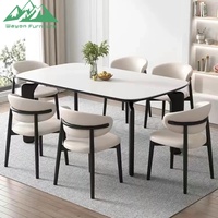 Ensemble de table à manger Wayon moderne avec plateau en marbre blanc, pieds architecturaux noirs, chaises rembourrées