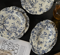 Assiettes en porcelaine émaillée bleu et blanc de style français classique moderne, série de vaisselle écologique à pied avec dentelle en relief, vente en gros