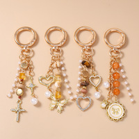 Nouveau porte-clés rond en alliage, breloque de sac en forme de croix, perles, papillon, cœur, très vendu